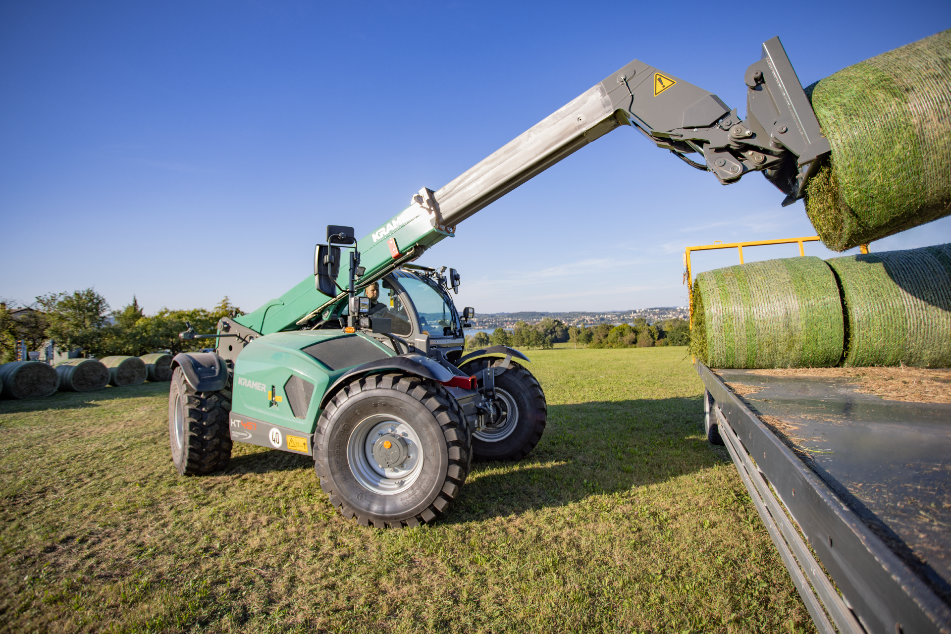 The KT457 loading a trailer with hay bales.