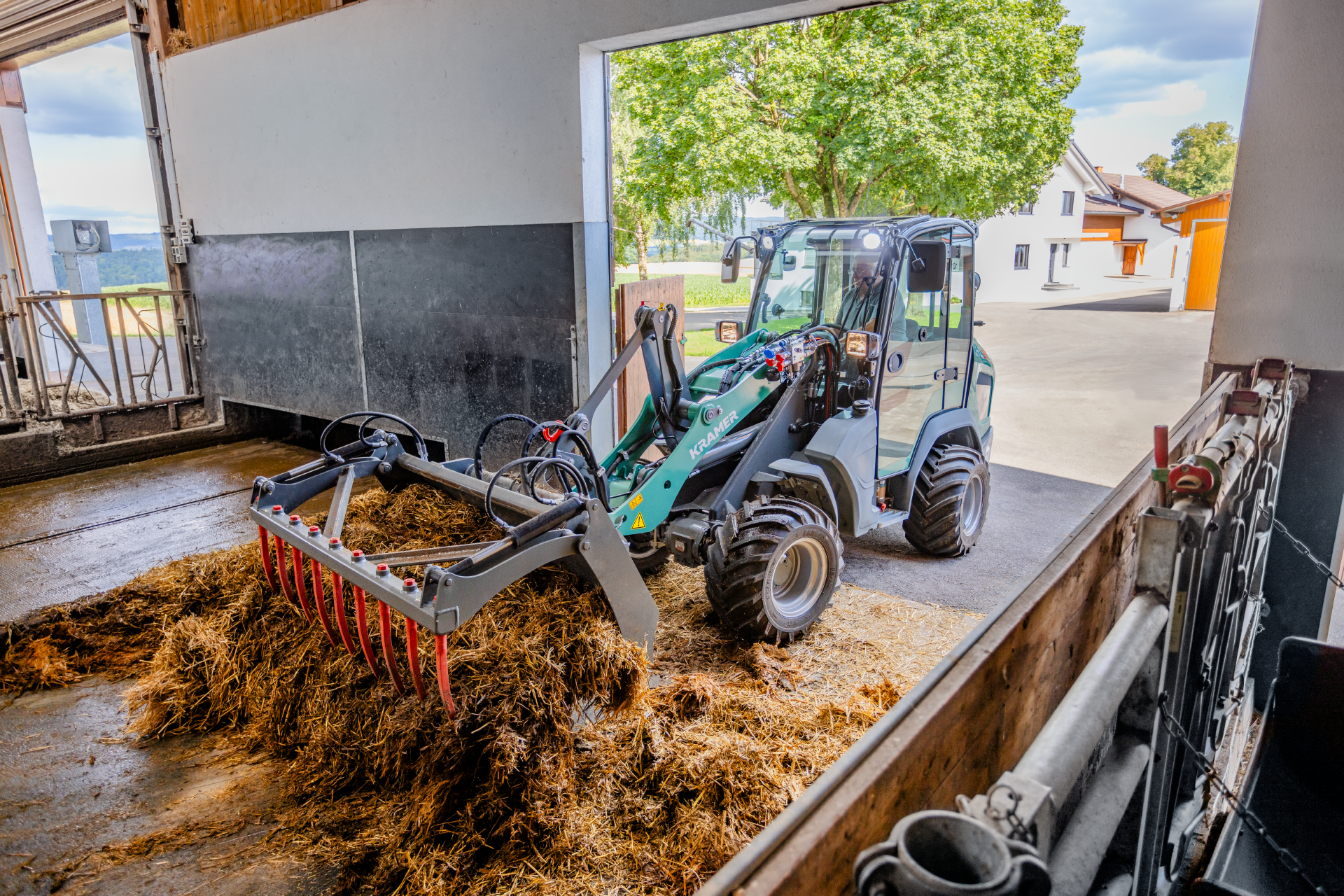 The Kramer KL21.5L wheel loader is used for working with silage in an agricultural environment.