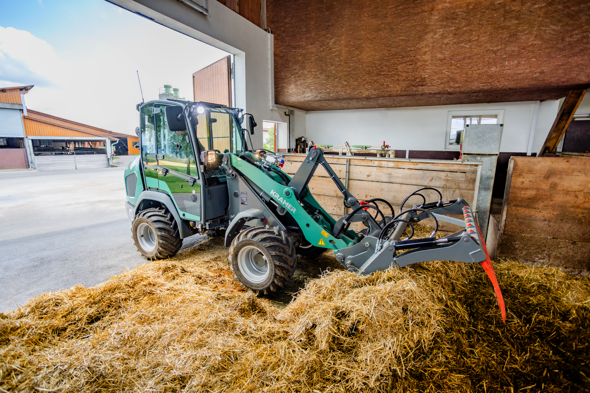 The Kramer KL21.5L wheel loader at work with straw bales.